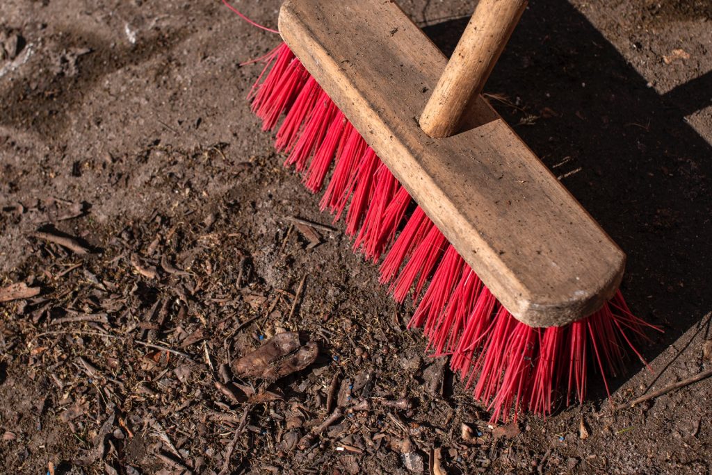 brown wooden handled brush on brown soil